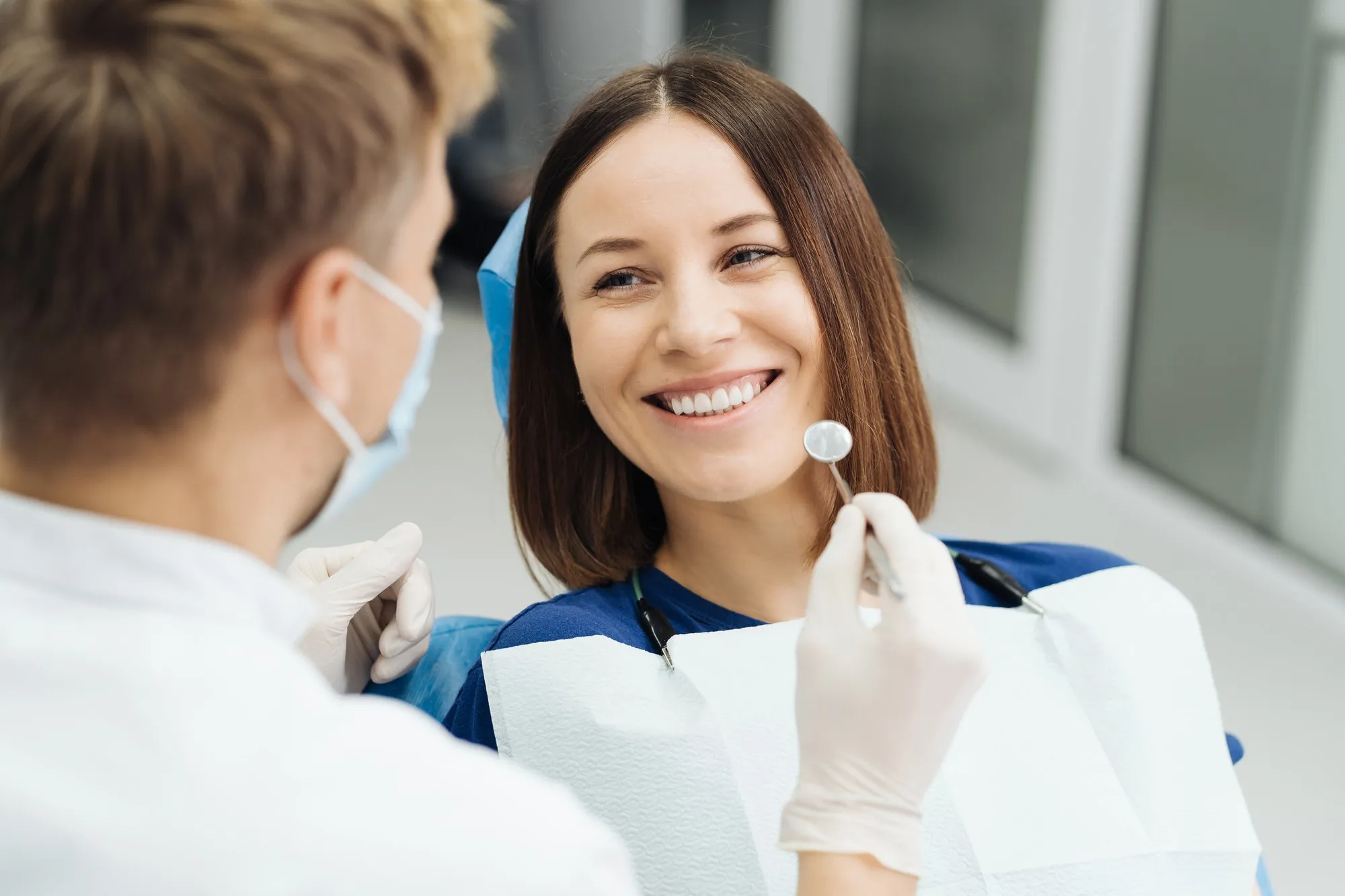 A smiling patient talking with her dentist during an exam